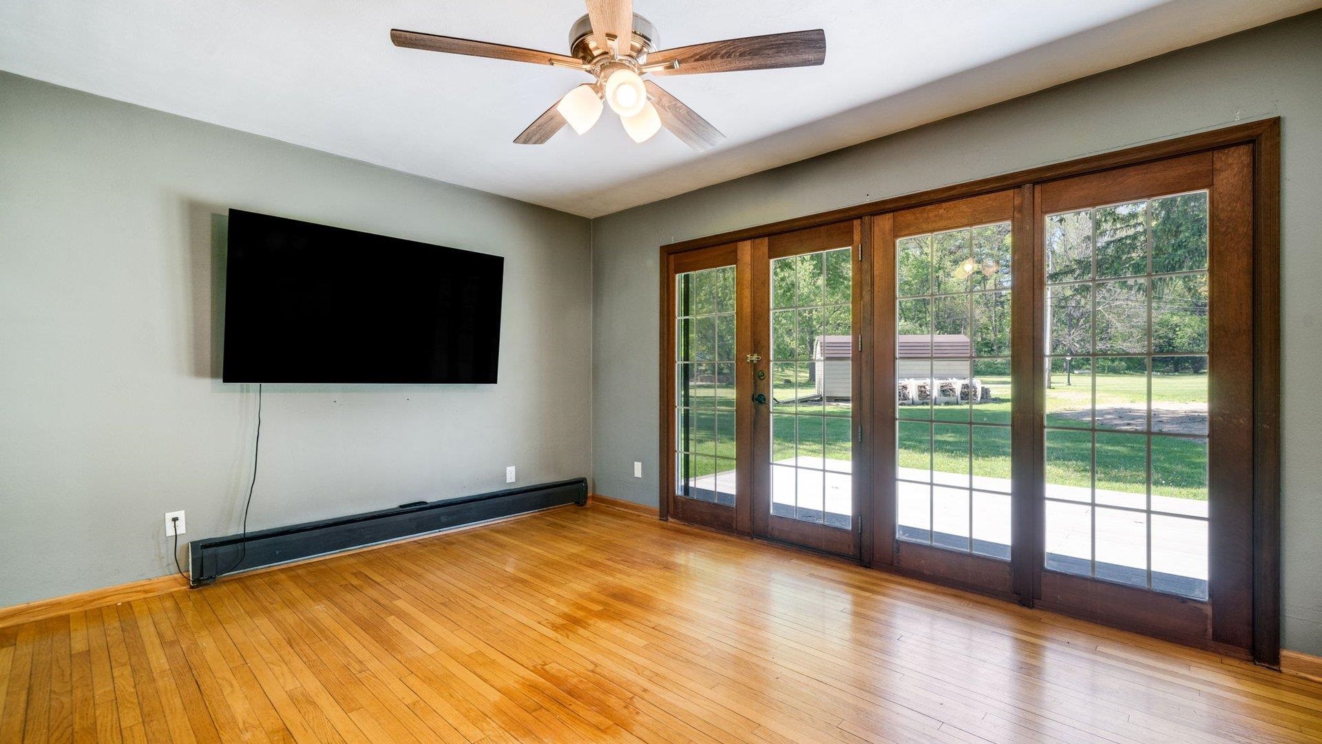 313 West Margaret Fuller Road Oregon, IL 61061 - Photo 12 of 46 a living room with a flat screen tv and a floor to ceiling window