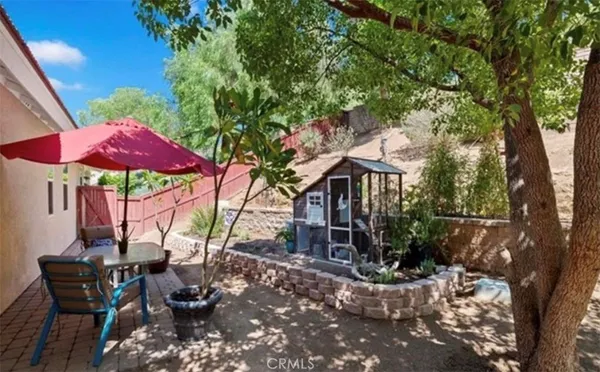 a view of a patio with chairs and table under an umbrella