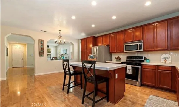 a kitchen with stainless steel appliances granite countertop wooden cabinets a stove top oven a granite counter top and stainless steel appliances