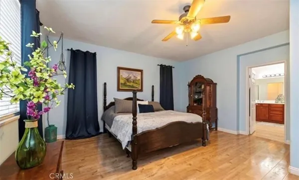a bedroom with a bed potted plant and a chandelier