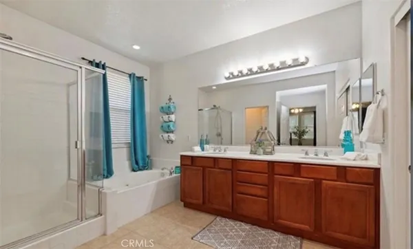 a bathroom with a double vanity sink mirror and bathtub