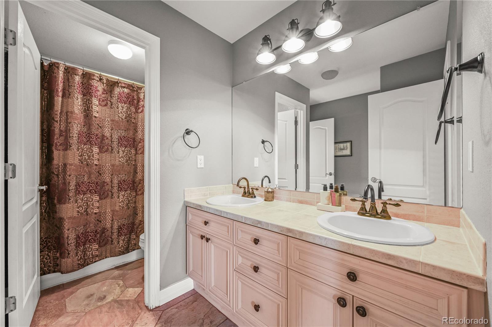 8518 High Ridge Court Castle Pines, CO 80108 - Photo 21 of 29 a bathroom with a double vanity sink mirror and shower