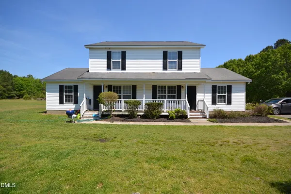 a view of a house with a yard patio and fire pit