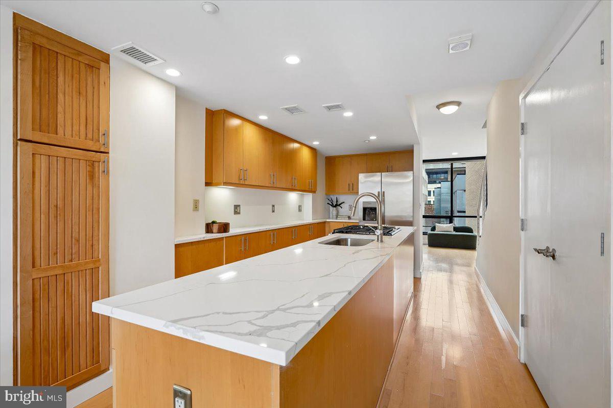 912 F Street Northwest, Unit 709 Washington, DC 20004 - Photo 4 of 28 a large kitchen with stainless steel appliances a large counter top