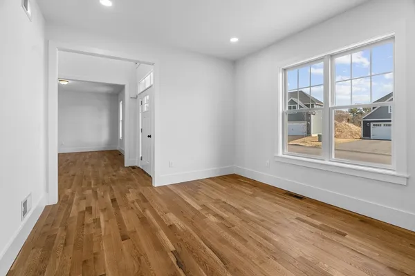 a view of a livingroom with wooden floor and a window