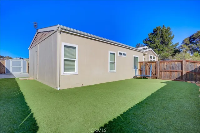 a view of a backyard with wooden fence and plants