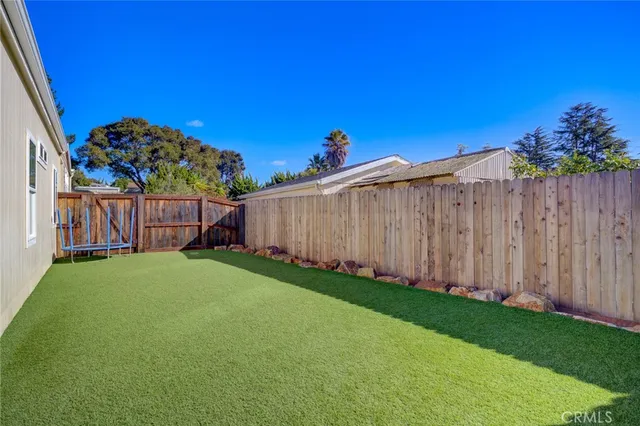 a view of a backyard with wooden fence