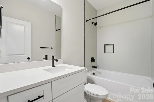 a bathroom with a sink a toilet a mirror a bathtub and shower