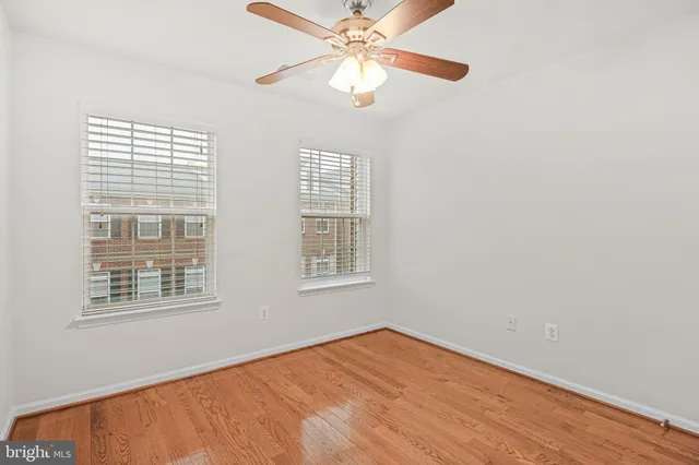 a view of an empty room with a window and a ceiling fan