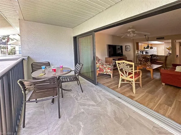 a dining room with furniture a rug and a large window