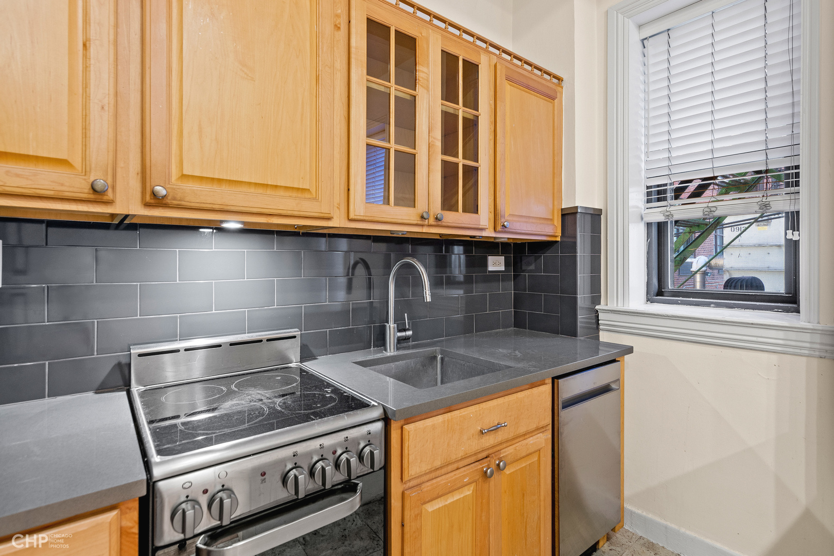 20 East Goethe Street, Unit 306 Chicago, IL 60610 - Photo 3 of 14 a kitchen with granite countertop a sink and a stove