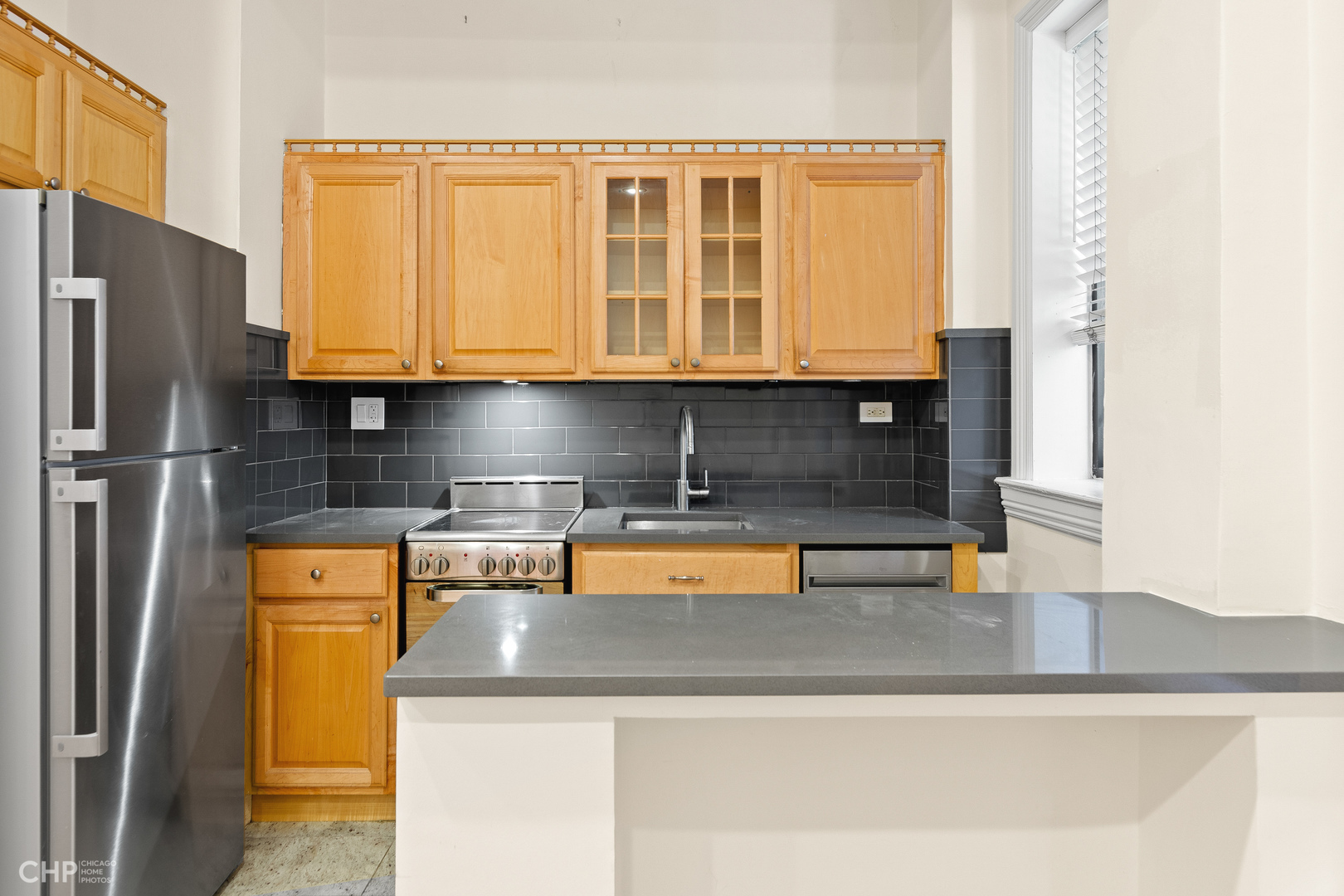 20 East Goethe Street, Unit 306 Chicago, IL 60610 - Photo 7 of 14 a kitchen with stainless steel appliances granite countertop a sink and a refrigerator