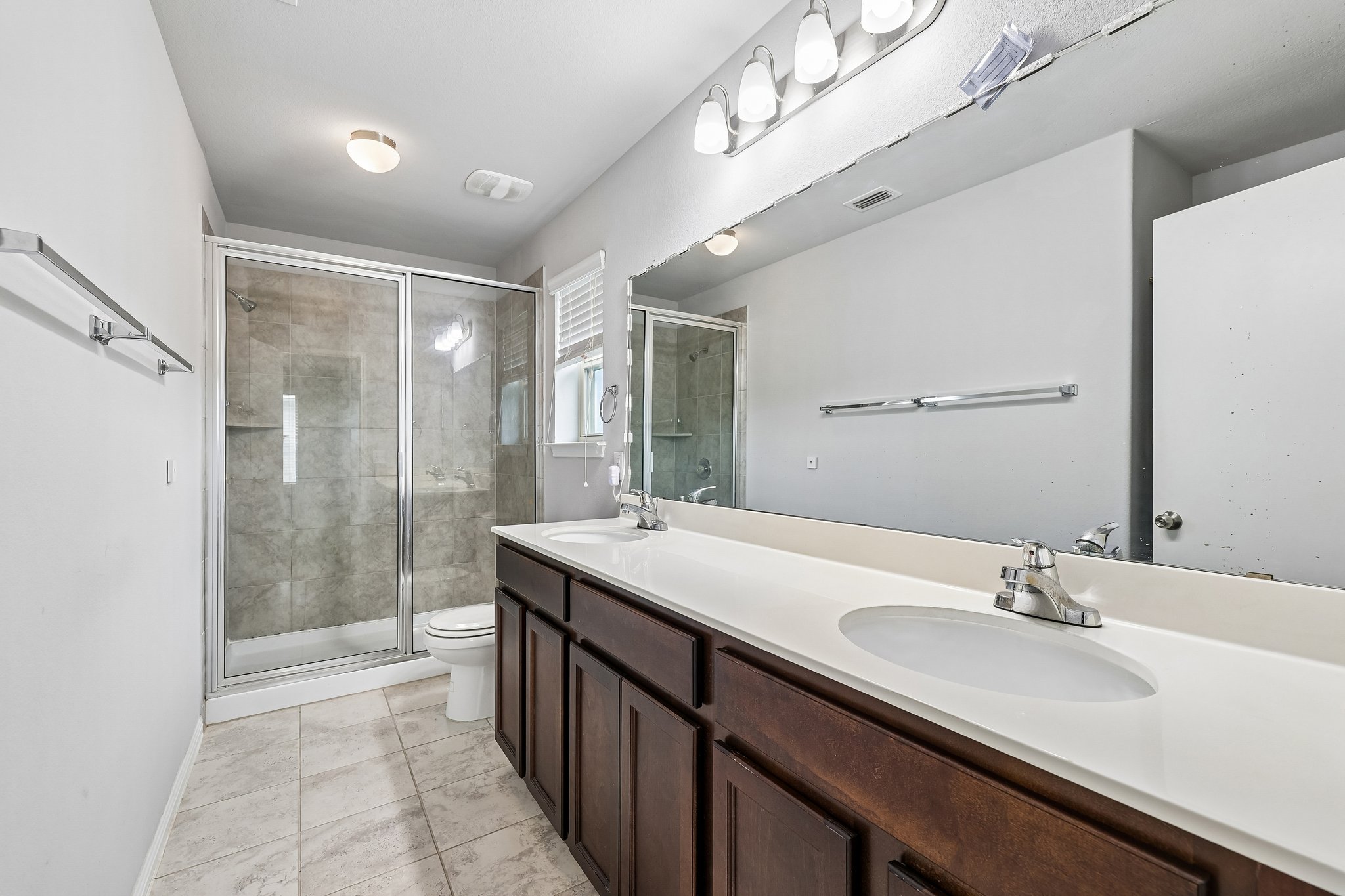 387 Guemal Road Buda, TX 78610 - Photo 32 of 39 Dual vanity with integrated sinks, brushed nickel faucets, and a full-width mirror