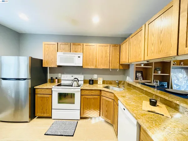 a kitchen with stainless steel appliances granite countertop a sink a stove and a microwave