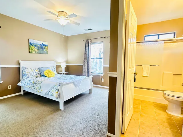 a bedroom with a bed dresser and a large window