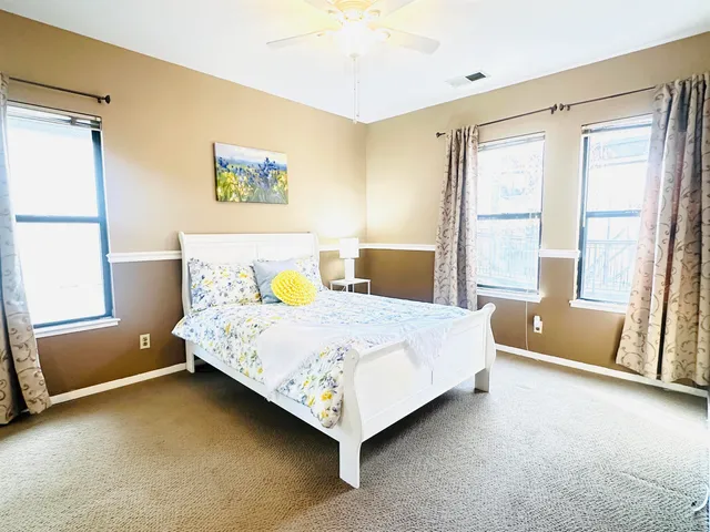 a bed sitting in a spacious bedroom next to a window