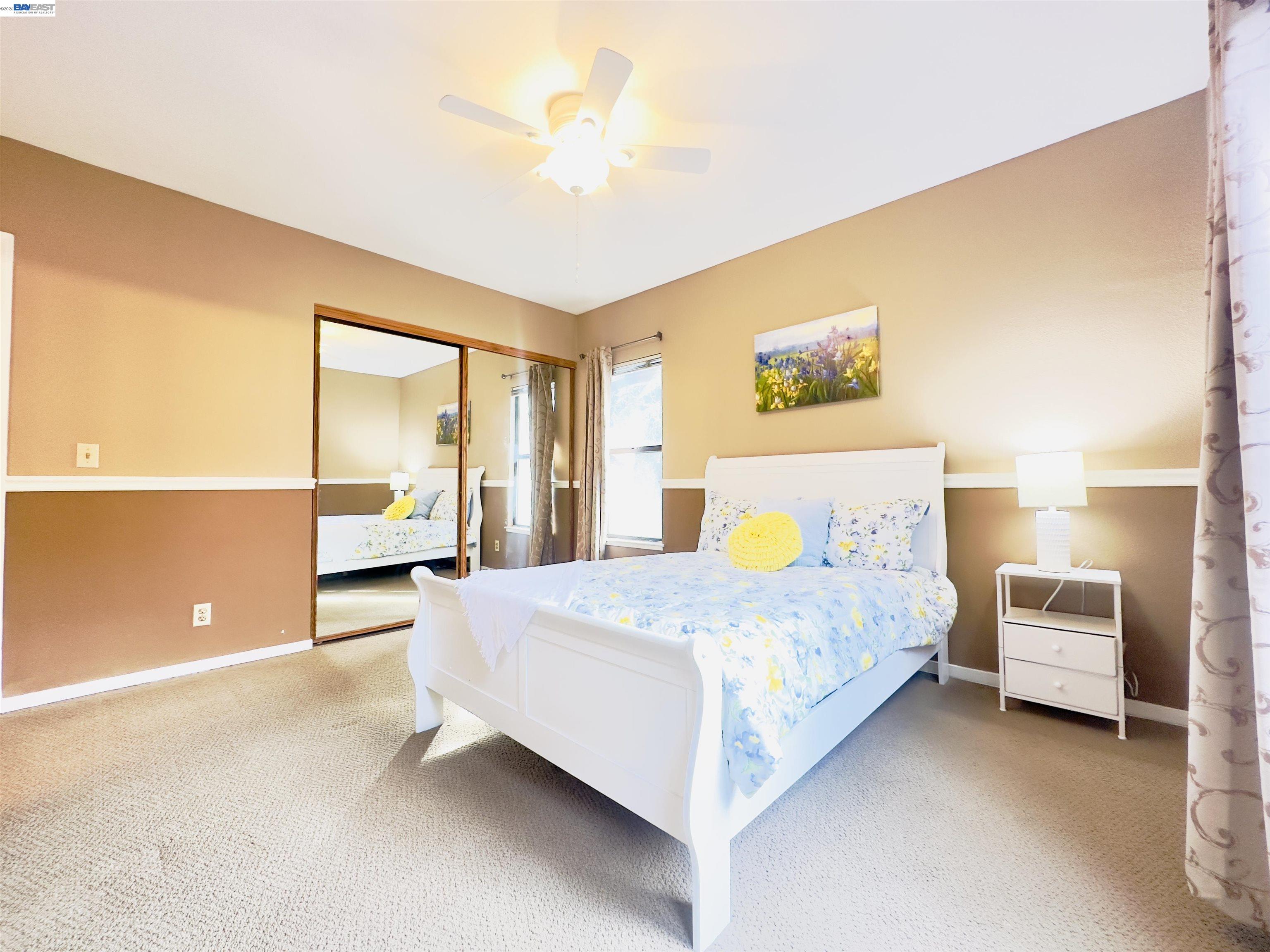 320 North Villa Way Walnut Creek, CA 94595 - Photo 18 of 36 a spacious bedroom with a bed and a chandelier