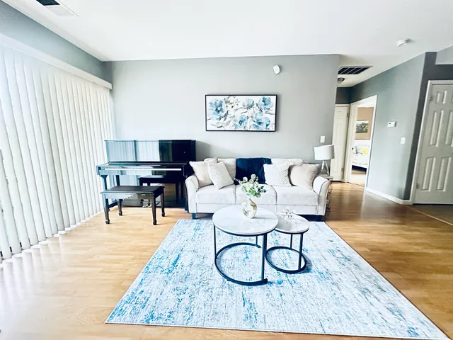a living room with furniture a wooden floor and a chandelier