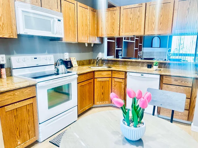 a kitchen with stainless steel appliances granite countertop a sink a stove and a wooden floors