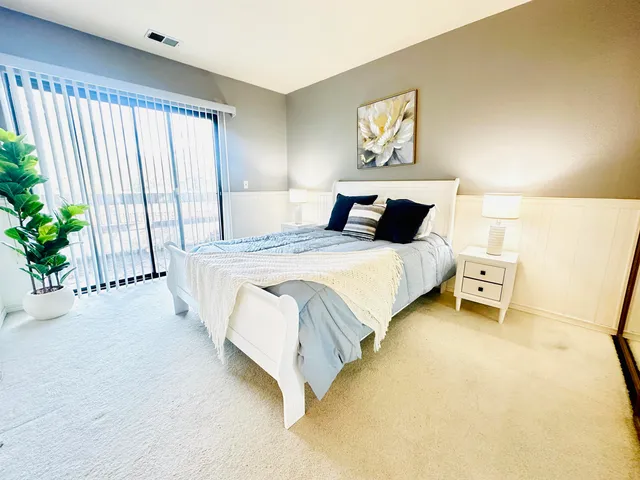 a bedroom with a bed and a large window