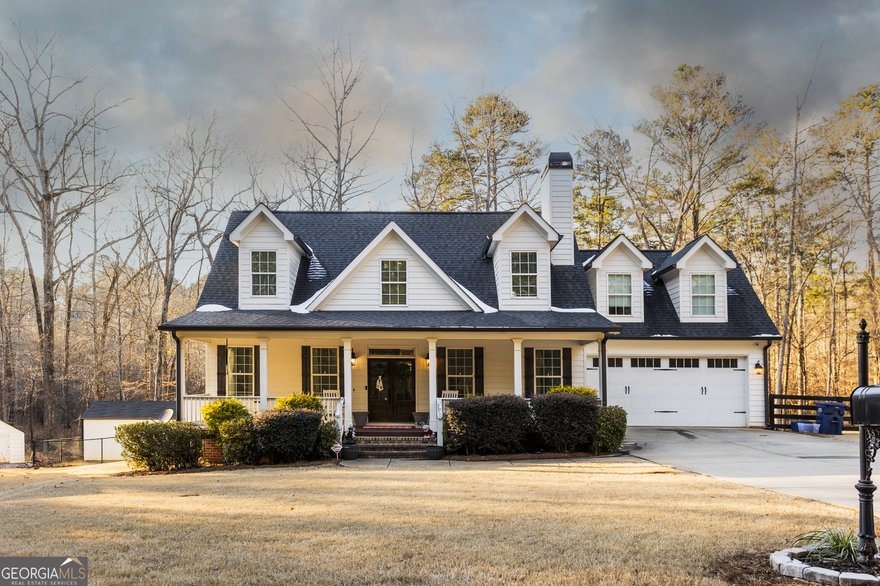 a front view of a house with a yard covered in snow