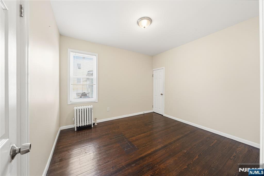 50 Unity Avenue Newark, NJ 07106 - Photo 8 of 42 an empty room with wooden floor and windows