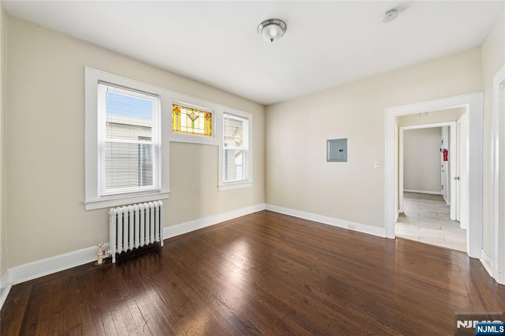 50 Unity Avenue Newark, NJ 07106 - Photo 10 of 42 an empty room with wooden floor and windows