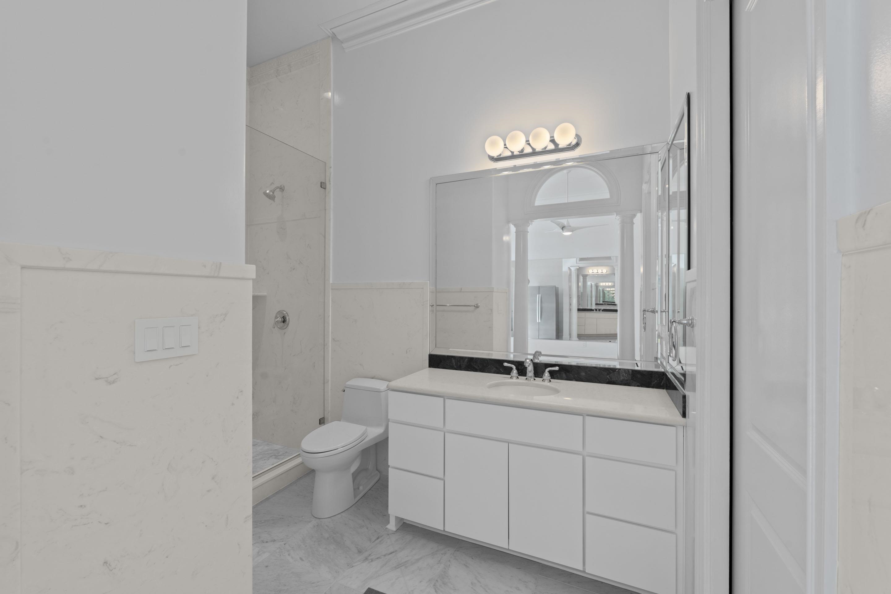881 Bray Station Road Collierville, TN 38017 - Photo 13 of 40 Bathroom featuring vanity, walk in shower, tile walls, light marble finish flooring, and a wainscoted wall