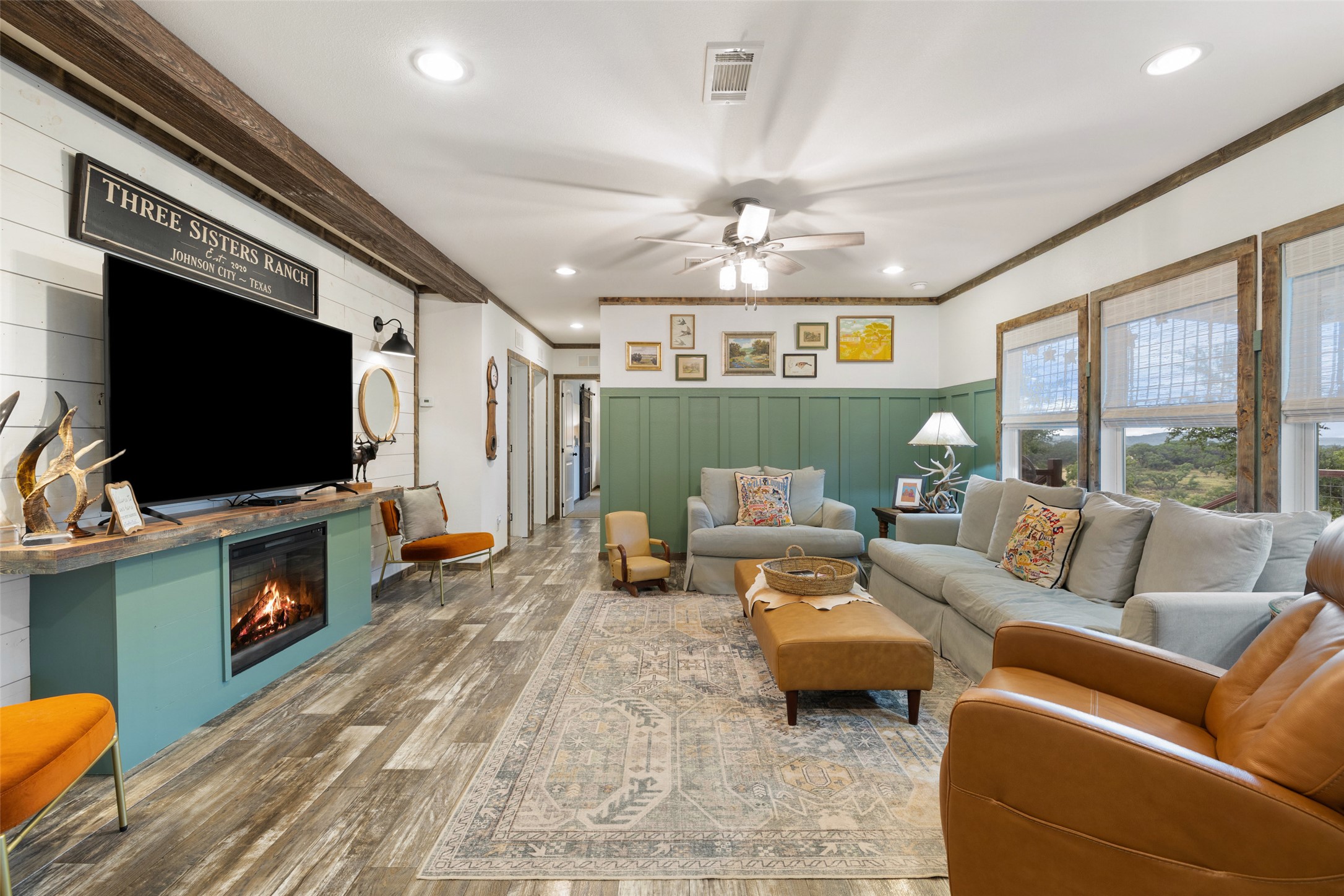 830 Ulrich Road Johnson City, TX 78636 - Photo 20 of 40 Natural light pours into this spacious living area, showcasing rustic wood accents and a modern fireplace.