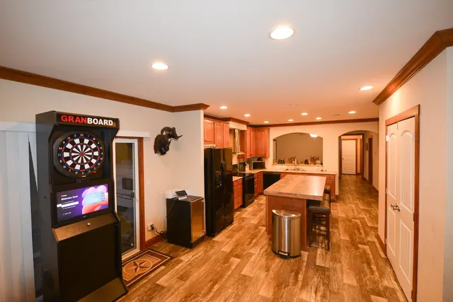 a kitchen with stainless steel appliances wooden floor dining table and chairs