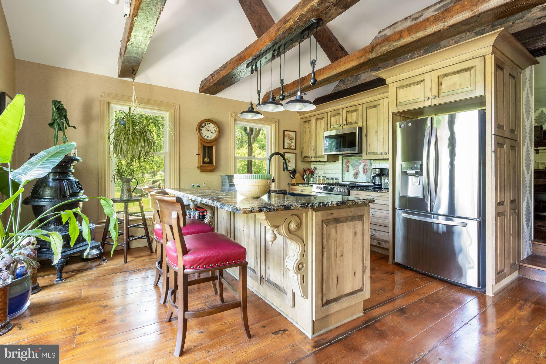 3150 Rushland Road Jamison, PA 18929 - Photo 22 of 50 a kitchen with stainless steel appliances granite countertop a stove a refrigerator a dining table and chairs with wooden floor