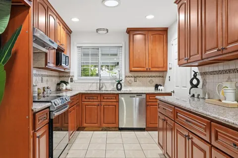 a kitchen with stainless steel appliances granite countertop a sink stove and cabinets