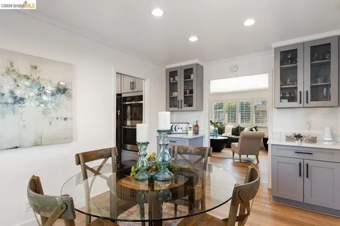 a dining room with furniture a large window and kitchen view