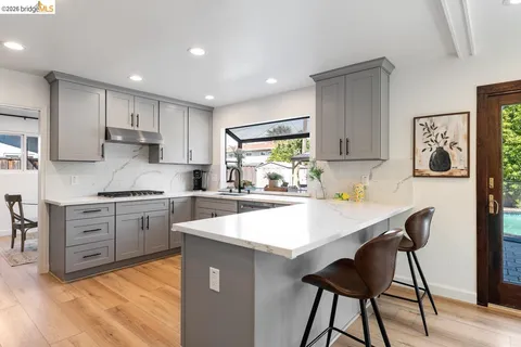 a kitchen with stainless steel appliances granite countertop a stove refrigerator sink and cabinets