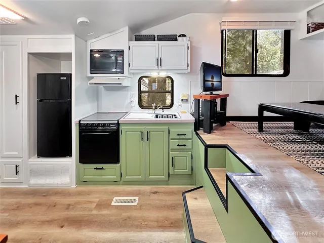 a kitchen with a refrigerator and a stove top oven