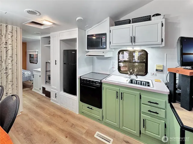 a kitchen with stainless steel appliances kitchen island a stove a refrigerator and cabinets
