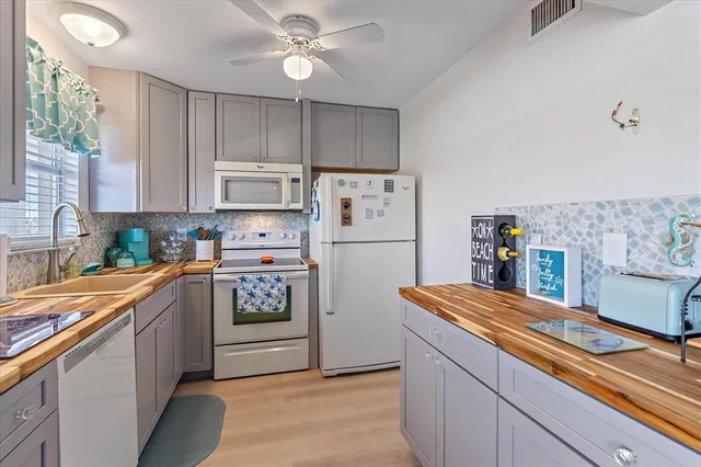a kitchen with stainless steel appliances a refrigerator a sink and white cabinets