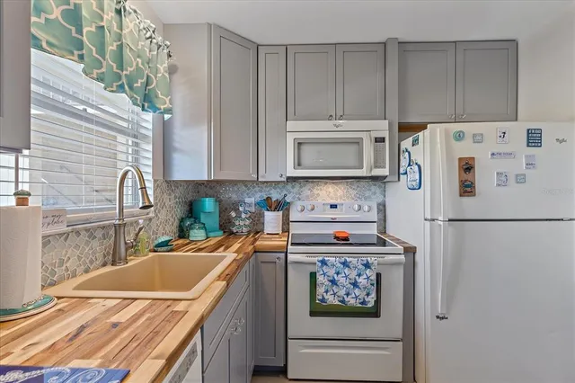 a kitchen with stainless steel appliances granite countertop a refrigerator sink stove and microwave