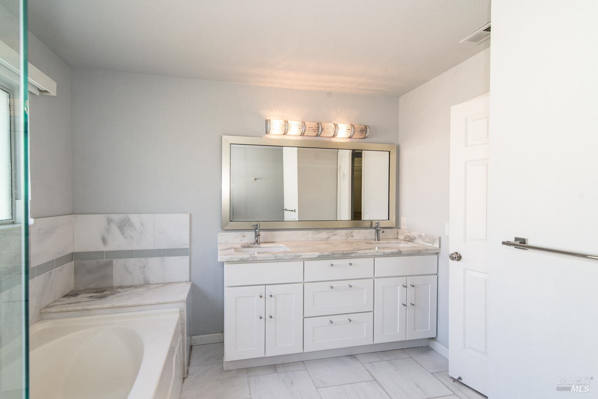 23 Baypoint Drive San Rafael, CA 94901 - Photo 25 of 40 a bathroom with a granite countertop sink and a mirror
