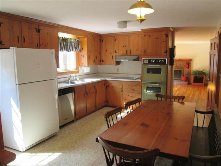 28 Eel Pond Road Monument Beach, MA 02532 - Photo 2 of 29 a kitchen with stainless steel appliances granite countertop a sink refrigerator stove dining table and chairs