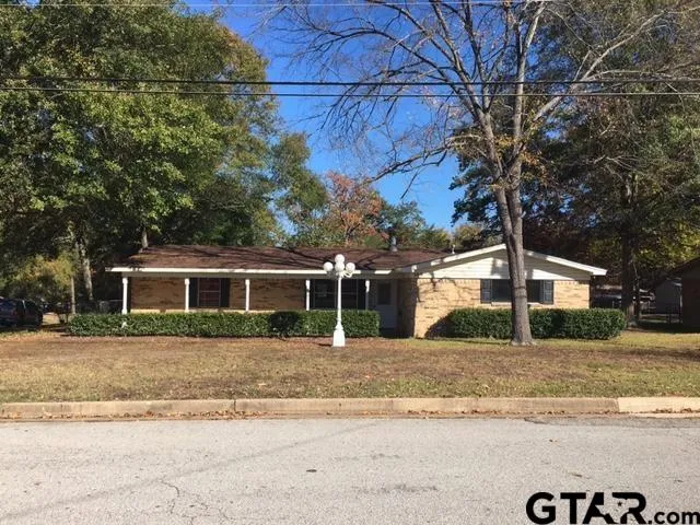 a front view of a house with a yard and trees