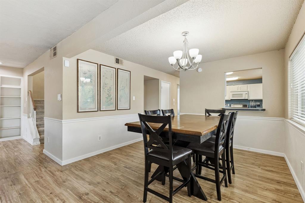 304 Lark Lane Euless, TX 76039 - Photo 16 of 32 Dining space featuring light wood-type flooring, a textured ceiling, and suspended lighting