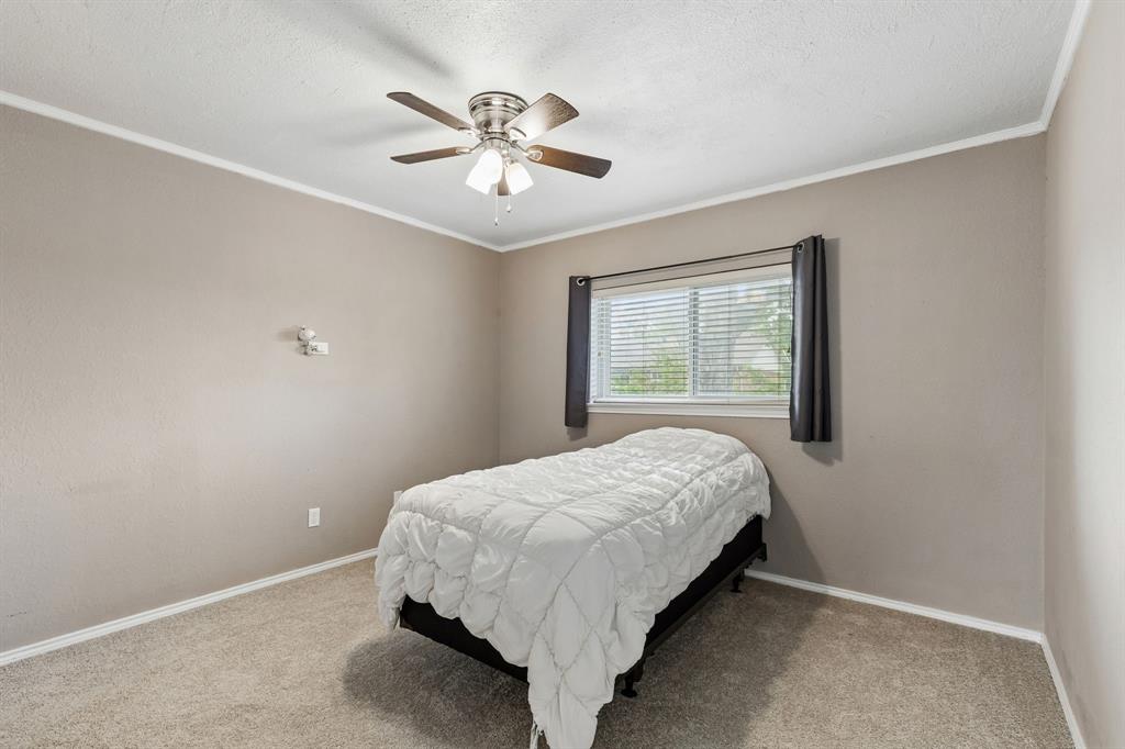304 Lark Lane Euless, TX 76039 - Photo 22 of 32 Bedroom with ceiling fan, crown molding, carpet, and a textured ceiling