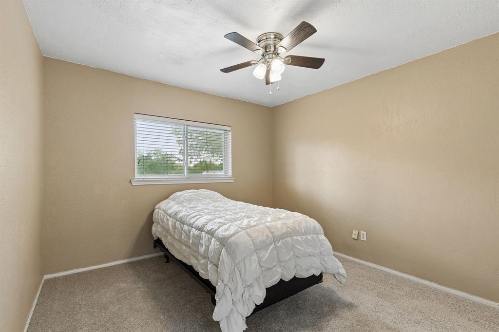 304 Lark Lane Euless, TX 76039 - Photo 23 of 32 Bedroom with ceiling fan, carpet, and a textured wall