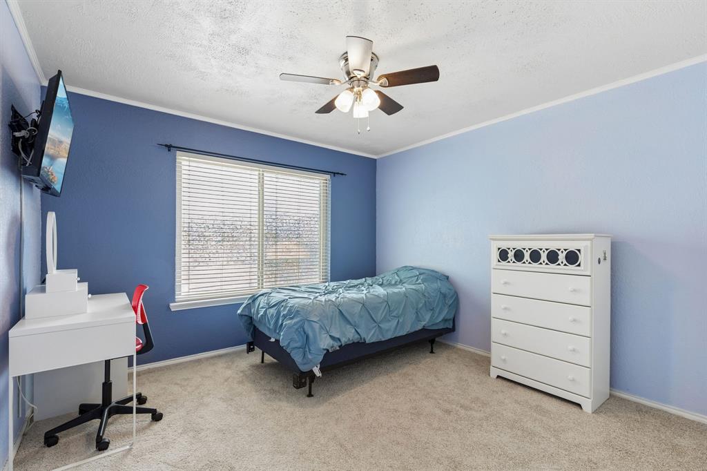 304 Lark Lane Euless, TX 76039 - Photo 24 of 32 Bedroom with light colored carpet, a ceiling fan, a textured ceiling, and ornamental molding