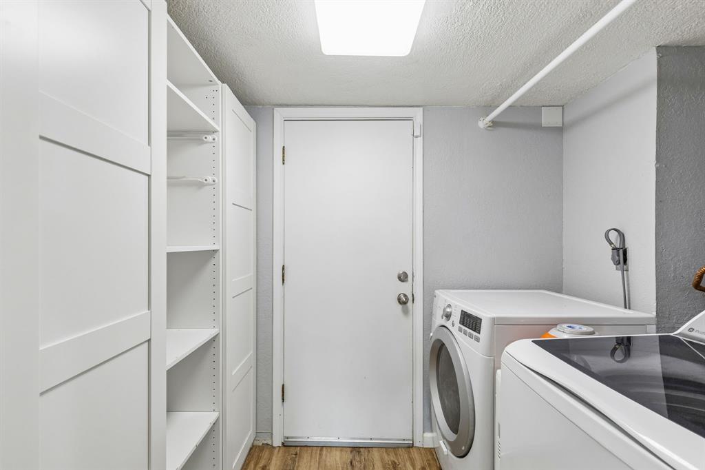 304 Lark Lane Euless, TX 76039 - Photo 27 of 32 Laundry room with a textured ceiling, light wood-style floors, and washer and clothes dryer