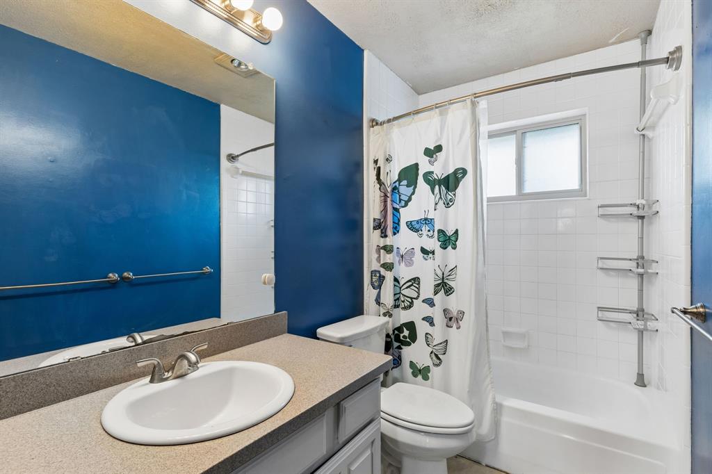 304 Lark Lane Euless, TX 76039 - Photo 28 of 32 Bathroom with vanity, shower / bath combo, and a textured ceiling