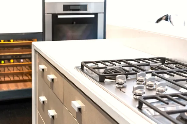 a large kitchen with kitchen island a stove a sink dishwasher and white cabinets with wooden floor