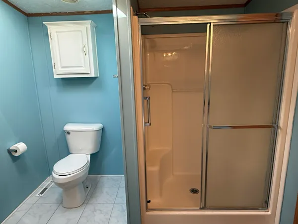 a bathroom with a toilet and a shower