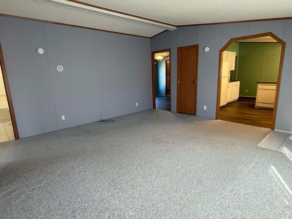 a view of an empty room with glass door and a window